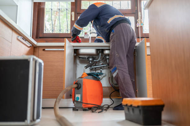 Plumber Unclogging A Kitchen Sink Drain With Pipe Cleaning Machine